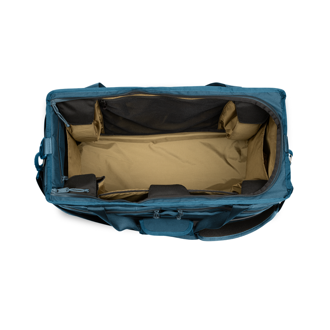 58L Mission Hauler Tote (Wander Blue) with main compartment open showing Coyote interior and pockets on a white background / Wander Blue